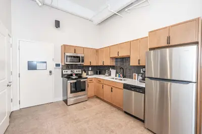 a kitchen with stainless steel appliances and wooden cabinets at The 333 Suites 202 - Stay for 6 in Cincinnati