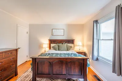 a bedroom with a wooden bed and a window at The Corner House in Ripley