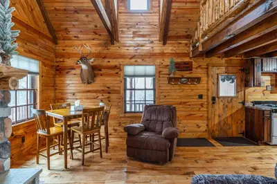 a dining room with a table and chairs in a log cabin at Wildlife Cabin