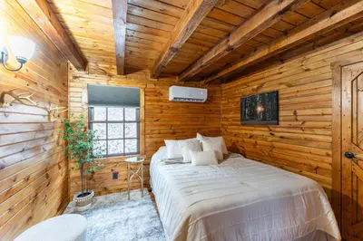 a bedroom with a bed in a wooden room at Wildlife Cabin