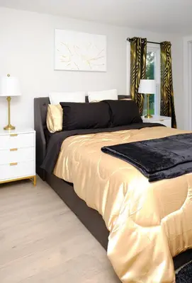 a bedroom with a large bed with gold sheets at Modern House near OSU and Short North in Columbus