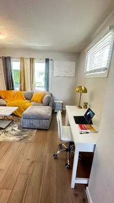 a living room with a couch and a desk with a laptop at Modern House near OSU and Short North in Columbus