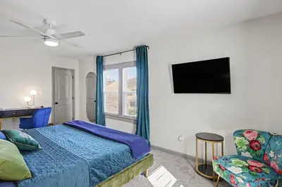 a bedroom with a bed and a tv and a chair at 2 Bedroom Home - Posh Princeton Pad in Columbus