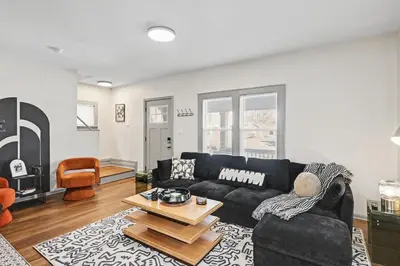 a living room with a black couch and a table at 2 Bedroom Home - Posh Princeton Pad in Columbus