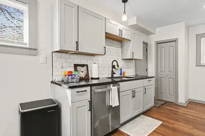 a kitchen with white cabinets and a sink and a dishwasher at 2 Bedroom Home - Posh Princeton Pad in Columbus