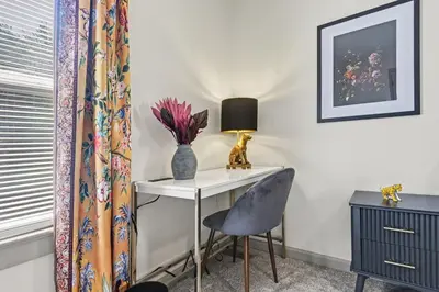 a room with a desk and a chair and a lamp at 2 Bedroom Home - Posh Princeton Pad in Columbus