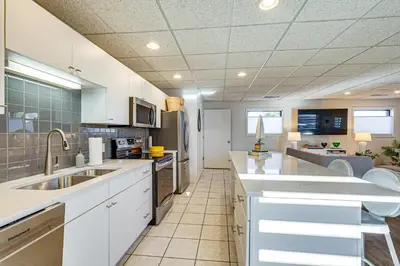 a large kitchen with white cabinets and appliances at Between Restaurant and Brewery! Chic Perrysburg Apt in Perrysburg