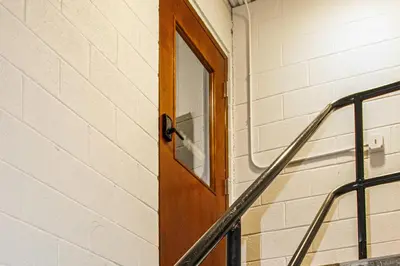 a wooden door in a building with a staircase at Between Restaurant and Brewery! Chic Perrysburg Apt in Perrysburg