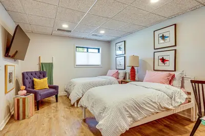 a bedroom with two beds and a purple chair at Between Restaurant and Brewery! Chic Perrysburg Apt in Perrysburg