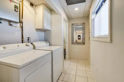 a laundry room with white appliances and a window at Between Restaurant and Brewery! Chic Perrysburg Apt in Perrysburg