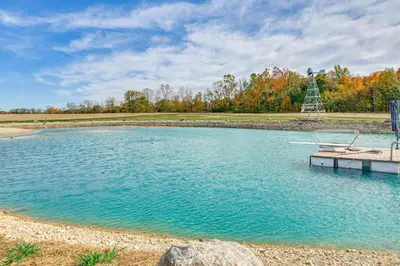a pool of water with a dock and a monument at Outdoor Oasis with Fire Pit and Dock Galion Log Cabin in Galion