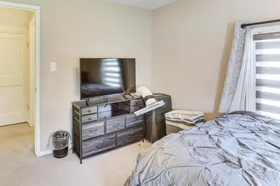a bedroom with a bed and a dresser with a television at Cozy Home 4 Mi to YSU Campus Penguins Welcome! in Youngstown