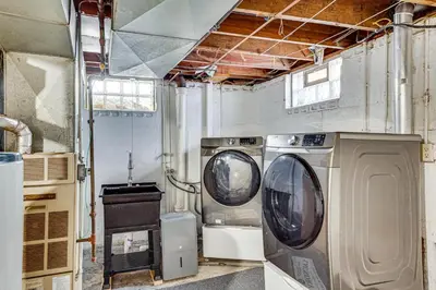 a laundry room with two washing machines in it at Cozy Home 4 Mi to YSU Campus Penguins Welcome! in Youngstown