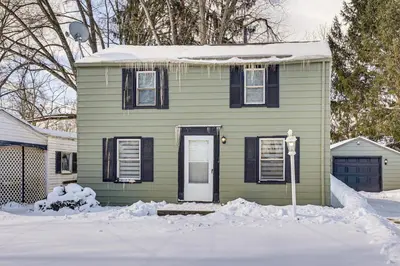a small green house with a snow covered yard at Cozy Home 4 Mi to YSU Campus Penguins Welcome! in Youngstown