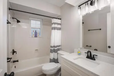 a white bathroom with a toilet and a sink at Spacious 4BR Near Botanical Gardens in Columbus