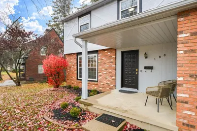 a brick house with a black door and a chair at Spacious 4BR Near Botanical Gardens in Columbus
