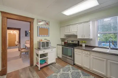a kitchen with white cabinets and a sink at Central Akron Stay! Large Victorian Home with Yard in Akron