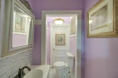 a bathroom with purple walls and a toilet and a sink at Central Akron Stay! Large Victorian Home with Yard in Akron