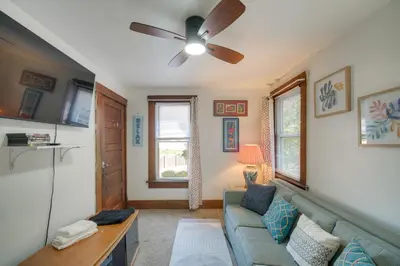 a living room with a couch and a ceiling fan at Central Akron Stay! Large Victorian Home with Yard in Akron