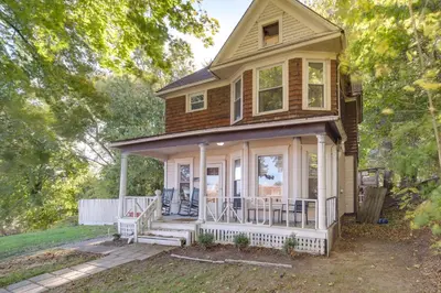 a small house with a porch and a front yard at Central Akron Stay! Large Victorian Home with Yard in Akron