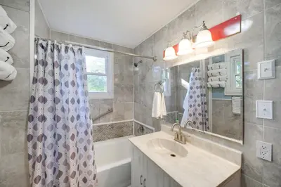 a bathroom with a sink and a shower curtain at Central Akron Stay! Large Victorian Home with Yard in Akron