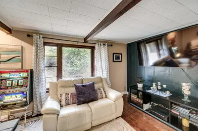 a living room with a couch and a tv at Easy Cleveland Access! Quiet Suburb Stay with Yard in Bedford