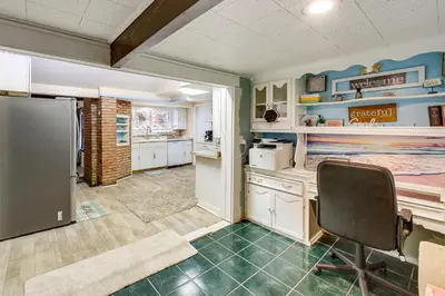 a kitchen with white cabinets and a refrigerator at Easy Cleveland Access! Quiet Suburb Stay with Yard in Bedford