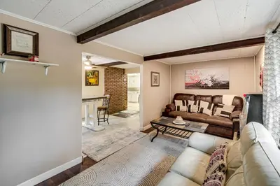 a living room with a couch and a table at Easy Cleveland Access! Quiet Suburb Stay with Yard in Bedford