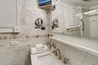 a bathroom with a sink and a toilet and a mirror at Easy Cleveland Access! Quiet Suburb Stay with Yard in Bedford