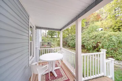 a white porch with a table and chairs on it at Modern and Convenient! Group Stay in Highland Square in Akron