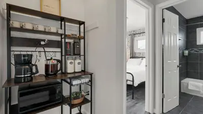 a kitchen with a microwave and a room with a bed at Hearth Home Brick Oven Karaoke 4 Bedroom fits 8 in Columbus