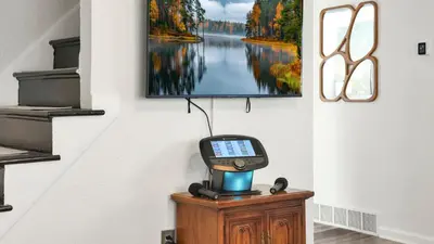 a tv on a wall with a phone on a table at Hearth Home Brick Oven Karaoke 4 Bedroom fits 8 in Columbus