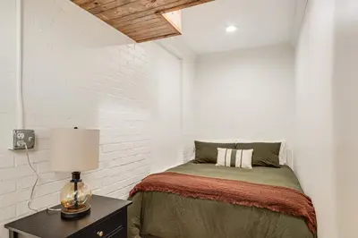 a bedroom with a bed and a table with a lamp at 2 Mi to Ark Encounter! Walkable Williamstown Condo in Williamstown