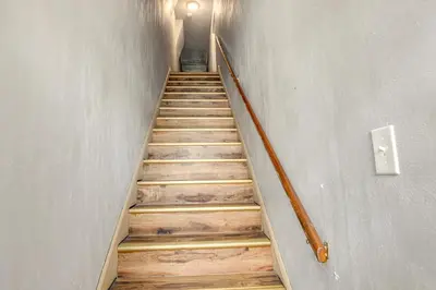 a staircase with wooden steps in a building at 2 Mi to Ark Encounter! Walkable Williamstown Condo in Williamstown