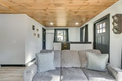 a living room with a couch and a wooden ceiling at Chène Cottage Near Burr Oak Lake and Trailheads! in Glouster