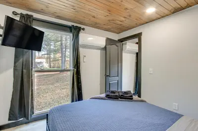 a bedroom with a bed and a large window at Chène Cottage Near Burr Oak Lake and Trailheads! in Glouster