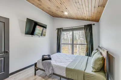 a bedroom with a bed and a tv and a window at Chène Cottage Near Burr Oak Lake and Trailheads! in Glouster