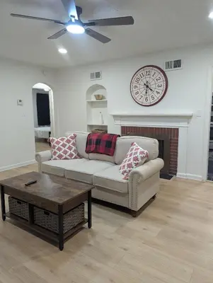 a living room with a couch and a clock on the wall at Oilgate at Parkgate in Akron