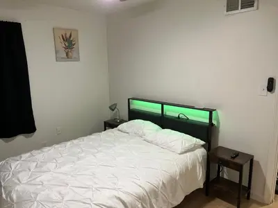 a bedroom with a white bed with a green headboard at Oilgate at Parkgate in Akron