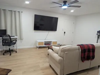 a living room with a couch and a flat screen tv at Oilgate at Parkgate in Akron