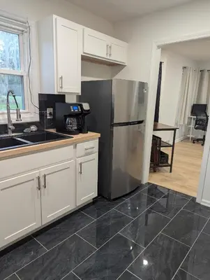 a kitchen with white cabinets and a stainless steel refrigerator at Oilgate at Parkgate in Akron