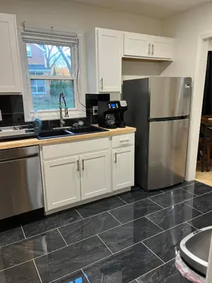 a kitchen with white cabinets and a stainless steel refrigerator at Oilgate at Parkgate in Akron