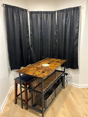 a wooden table and a black curtain in a room at Oilgate at Parkgate in Akron