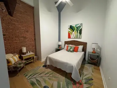 a bedroom with a bed and a brick wall at Downtown Condo 5 Minutes to Cedar Point in Sandusky
