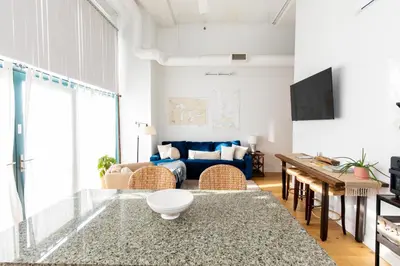 a living room with a blue couch and a table at Downtown Condo 5 Minutes to Cedar Point in Sandusky