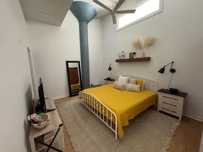 a bedroom with a bed with a yellow blanket at Downtown Condo 5 Minutes to Cedar Point in Sandusky