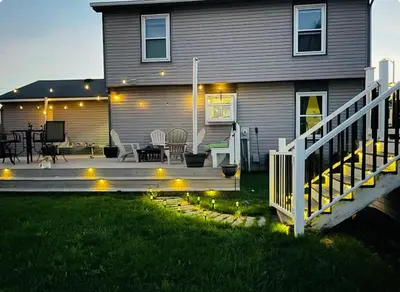 a house with a deck with lights in the yard at Cozy boho Retreat in Grove City