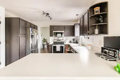 a kitchen with black cabinets and a white counter top at Cozy boho Retreat in Grove City