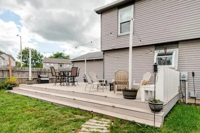 a large wooden deck with chairs and a table at Cozy boho Retreat in Grove City
