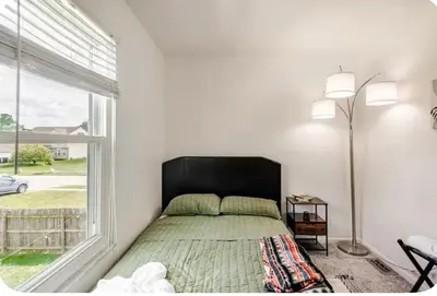 a bedroom with a bed and a large window at Cozy boho Retreat in Grove City
